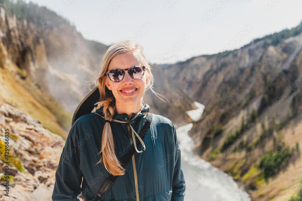 Young woman smiling at the top of the Grand Canyon of the Yellowstone River, in Yellowstone National Park