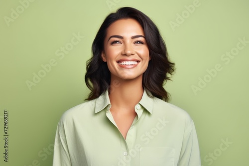 Portrait of happy smiling young beautiful woman in casual green shirt, over green background