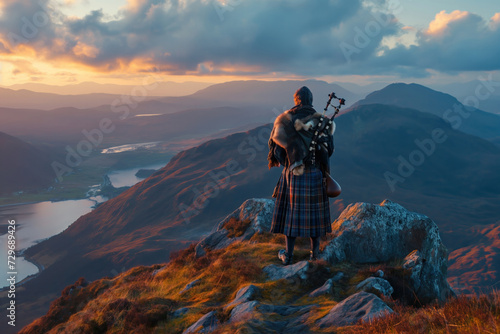 A Scottish dressed traditional plays the bagpipes on the peak of the Scottish High Lands with a breathtaking view