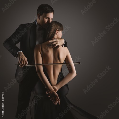Sexy Couple Kiss. Musician Man with Violin Bow playing Cello Woman Body. Classical Love Music Artist Perform over Black. Art Photo
