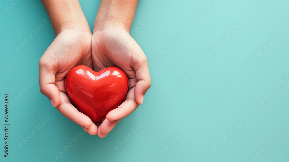 Two hands cradling a shiny red heart against a calming turquoise backdrop, symbolizing care and love. Two hands cradling a shiny red heart against a calming turquoise backdrop, symbolizing care and love.