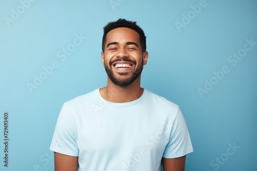 happy african american man in t-shirt on blue background © Igor