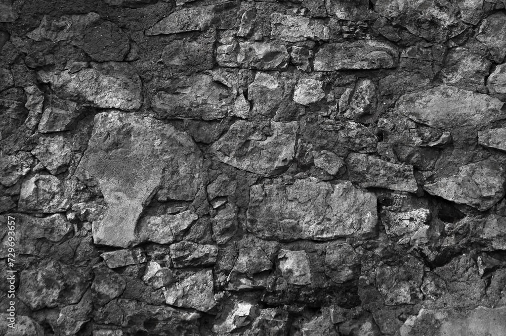 in the photo there is an old gray stone wall close up in the photo there is an old gray stone wall close up