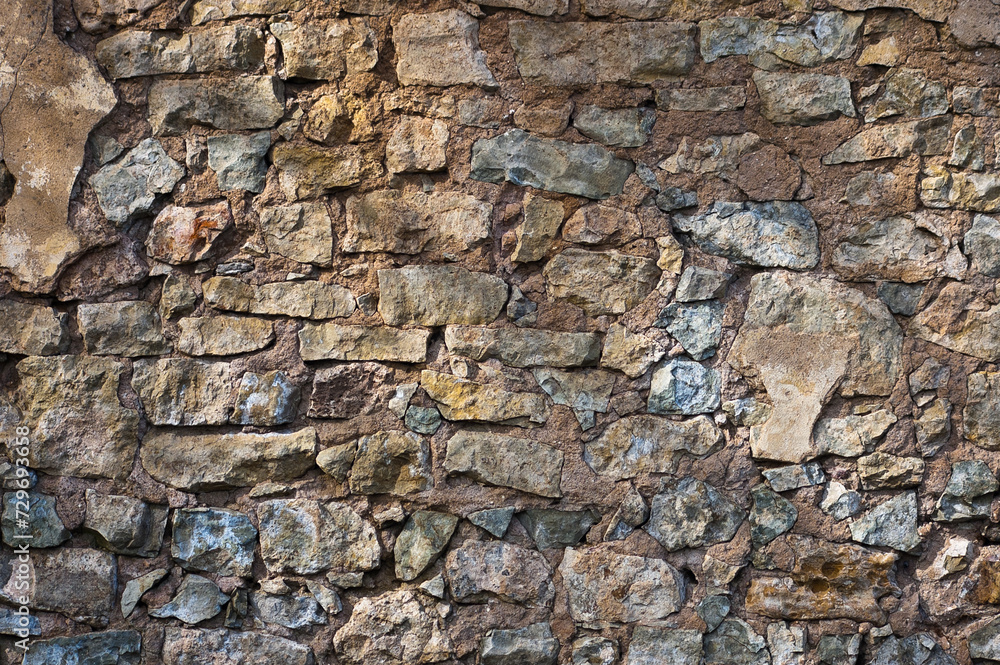 in the photo there is a close-up of an old stone wall in the photo there is a close-up of an old stone wall