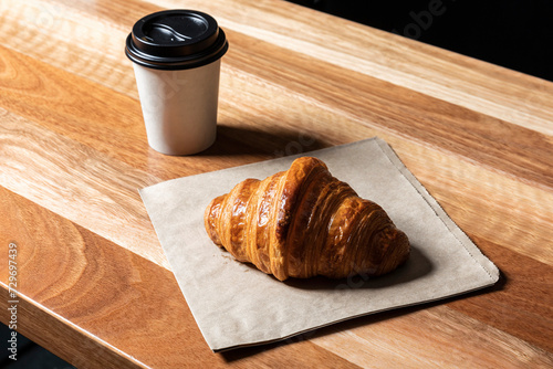 Croissant and Takeaway Coffee in a Paper Cup