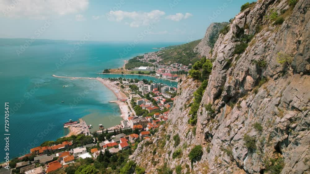 Elevated view of a coastal town Omis by the sea with a mountain backdrop. Summer Popular tourist destination in Croatia. Elevated view of a coastal town Omis by the sea with a mountain backdrop. Summer Popular tourist destination in Croatia.
