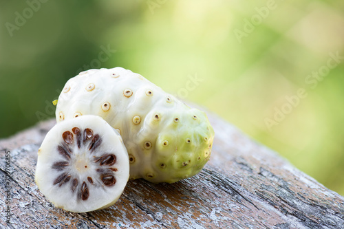 Noni or Morinda citrifolia fruits on natural background.