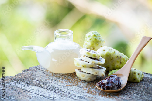 Canvas Print Noni or Morinda citrifolia fruits ,juice and seeds on natural background