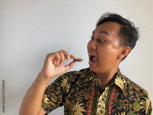 Asian man is eating chocolate wafer