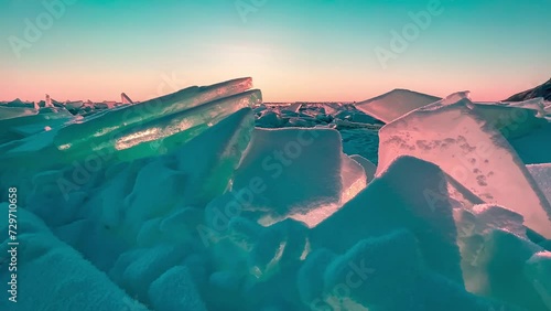 Frozen winter lake Baikal Siberia Russia. Ice blocks and hummocks in the snow. Strong wind and snowstorm on blue transparent ice. Natural cold ice background. Winter abstract background.  photo