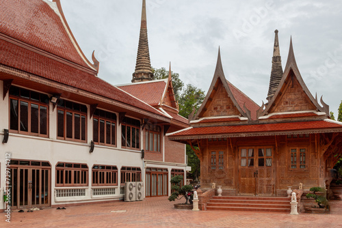 Red brick and wood traditional buddhist temple design architecture complex of the Wat Yai Chai Mongkhon historical park in Ayutthaya Thailand on a cloudy day