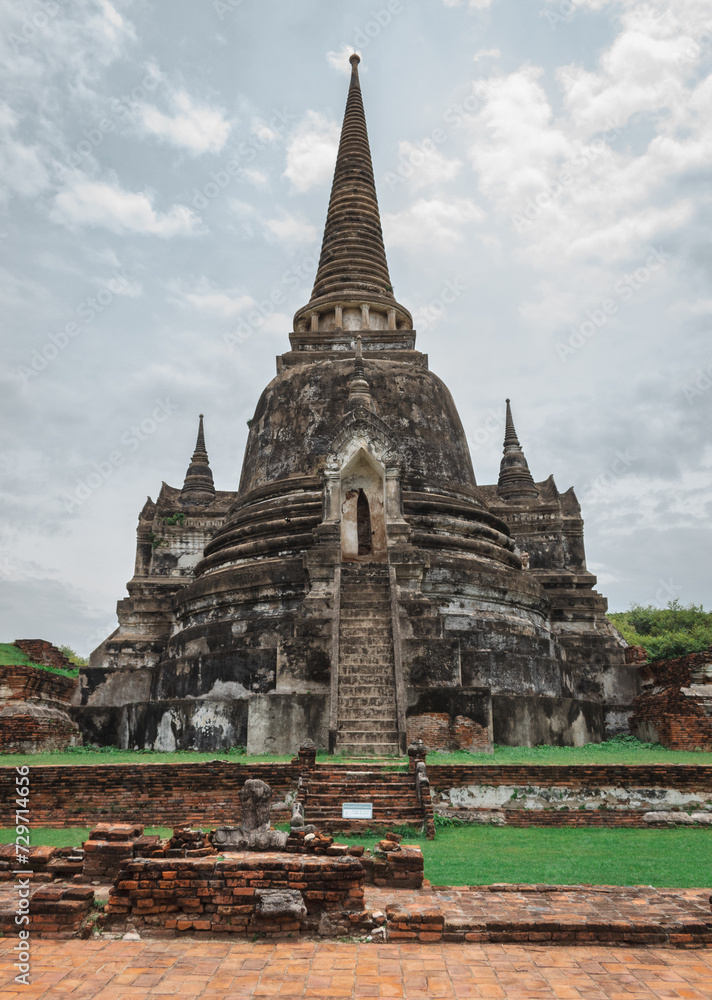 Traditional Thai stone pagoda building structure ruins at Wat Phra Si Sanphet temple in Ayutthaya Thailand historical park on a cloudy day