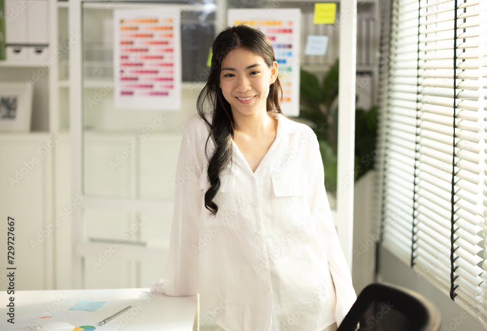 Confident Asian Female Entrepreneur Full of Enthusiasm in a Startup Office Confident Asian Female Entrepreneur Full of Enthusiasm in a Startup Office
