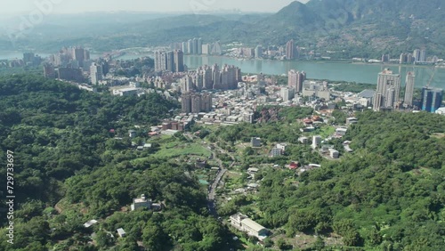 Zhuwei district in Taipei with urban skyline and greenery, river in background, Aerial photo