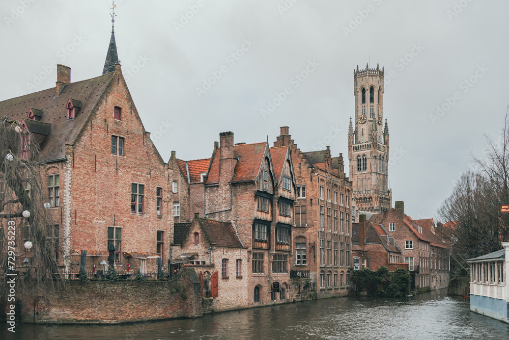 Beautiful city skyline of the village building architecture along a river rozenhoedkaai Rosary Quay canal reflection in Brugge Flanders Belgium on a cloudy day