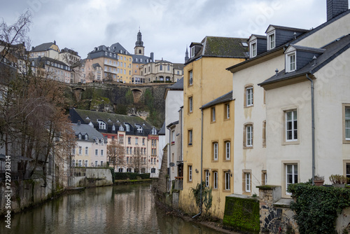 Colorful pink, yellow, and grey buildings in the old town village along a canal river reflection of Luxembourg City Europe