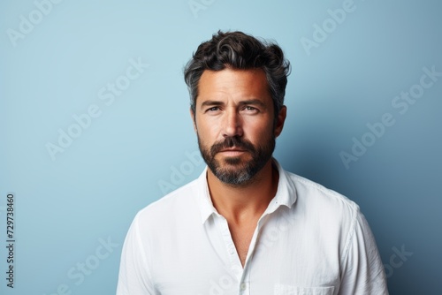 Handsome bearded man in a white shirt on a blue background