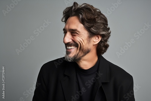 Handsome middle aged man laughing and looking at the camera.
