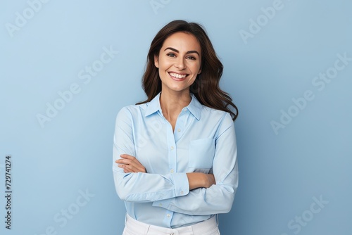 Portrait of happy smiling young business woman, isolated over blue background