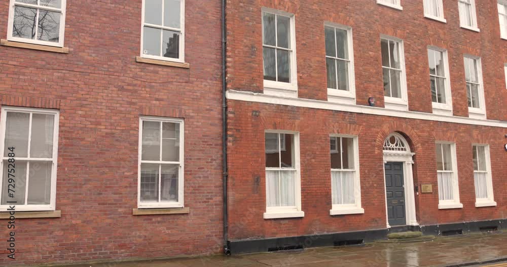 Brick architecture of a building beside wet street during rainy day in Manchester, England. Brick architecture of a building beside wet street during rainy day in Manchester, England.