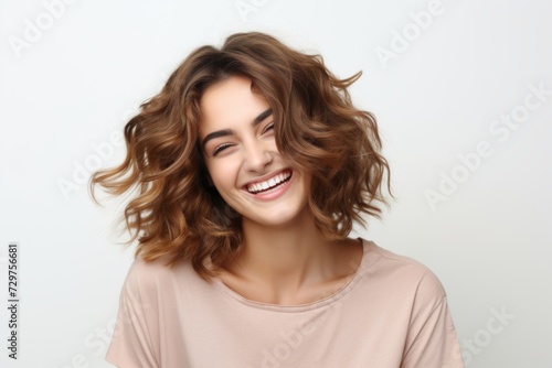 Portrait of a happy young woman with long wavy hair.