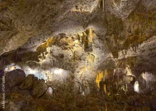 The inside of a cave in Carlsbad Caverns National Park in New Mexico. This dark cave has a lot of stalactites and stalagmites.