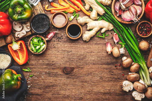 Vegan food and cooking background. Wooden table with vegetables, spices and ingredients for preparing vegetarian Asian dishes with mushrooms and soy sauce. top view, copy space