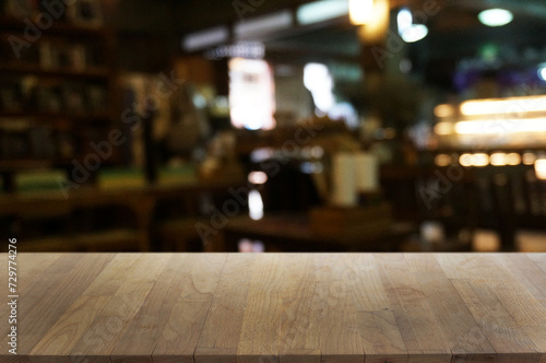 Empty dark wooden table in front of abstract blurred boken bankground of restaurant. Can used for display or montage your products. Mock up for space.