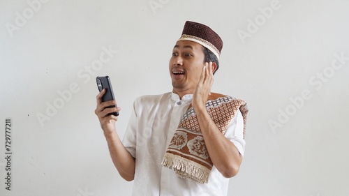Asian Moslem man excited happy when in video call using mobile phone