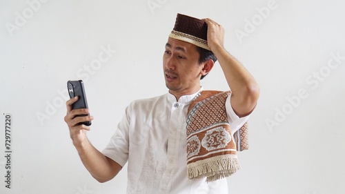 Asian Moslem man excited happy when in video call using mobile phone photo