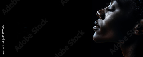 Close up of a model black woman face profile on a black background