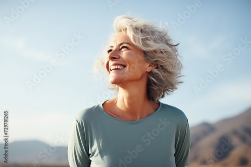 Outdoor portrait of a beautiful middle aged woman smiling and looking up