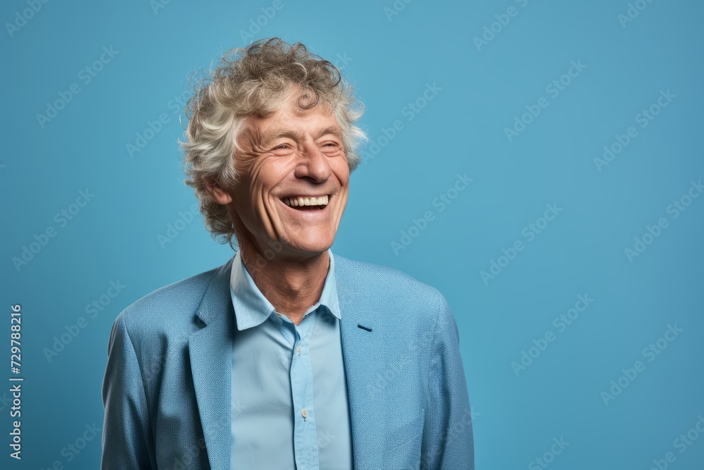 Portrait of a happy senior man laughing and looking at camera against blue background Portrait of a happy senior man laughing and looking at camera against blue background