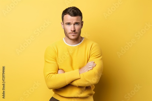 Portrait of a handsome young man in yellow sweater over yellow background