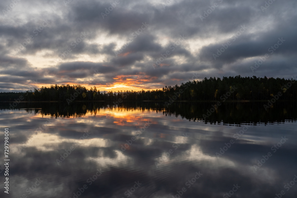 Reflection on the water surface of a lake on a tranquil and partly cloudy morning