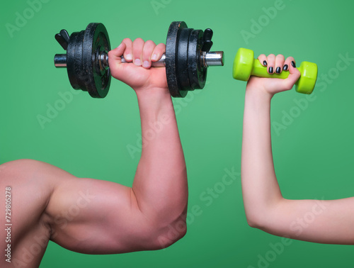 Dumbbell workout isolated green studio background. Hands with dumbbells close-up. Training with Dumbbells. Female and male hand holds dumbbell. Muscular hands, exercises with dumbbells.