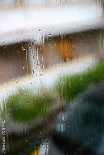 Water drops on the glass window on a rainy day.Rainwater runs down the window pane. Street or city scene background.Rome,Italy,Europe.