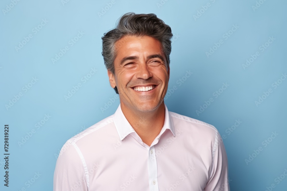 Portrait of a happy mature man smiling at camera against blue background Portrait of a happy mature man smiling at camera against blue background