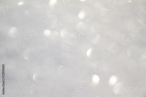 Blurred white bokeh background, snow sparkles in the sun