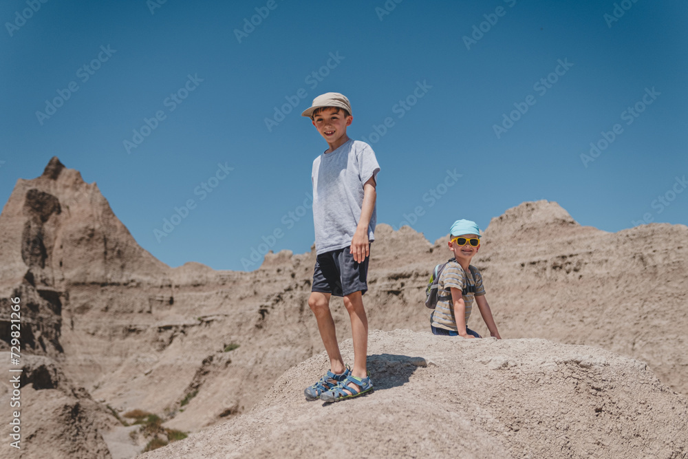 Two brothers smiling while exploring the rock formations of Badlands National Park
