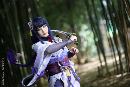 Portrait of a beautiful young woman game cosplay with samurai dress costume on Japanese garden
