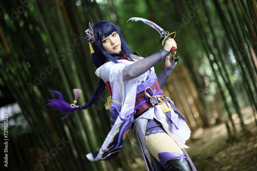 Portrait of a beautiful young woman game cosplay with samurai dress costume on Japanese garden