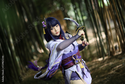 Portrait of a beautiful young woman game cosplay with samurai dress costume on Japanese garden