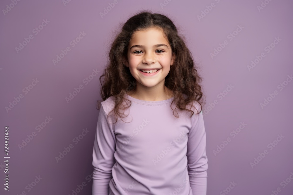 Portrait of a smiling little girl with long curly hair on a purple background Portrait of a smiling little girl with long curly hair on a purple background
