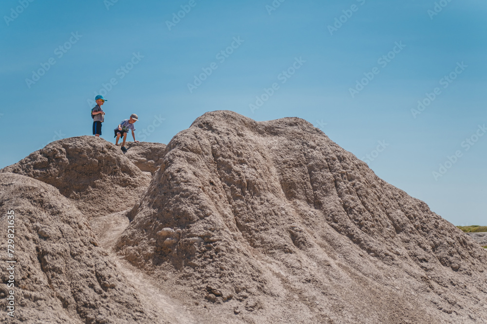 Two brothers climbing the rock formations of Badlands National Park