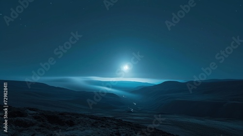  a view of a mountain range at night with a bright light in the middle of the sky and a bright light at the top of the mountain in the distance.