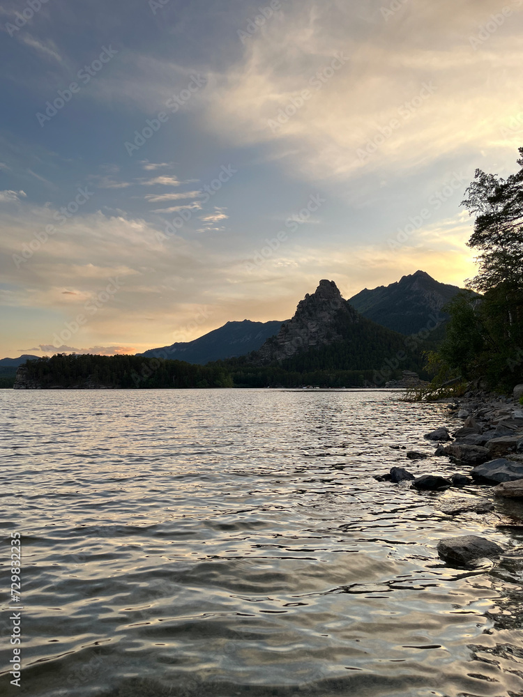 Serene Twilight Scene with Majestic Mountains, Reflective Lake, and Lush Pine Trees