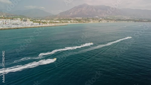 Jet skis racing near puerto banus in marbella with scenic mountains, aerial view photo