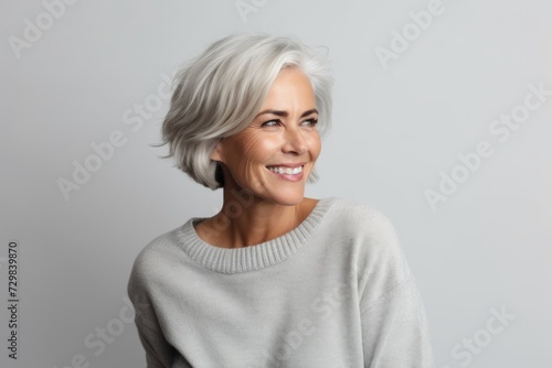 Portrait of beautiful middle-aged woman with grey hair smiling at camera
