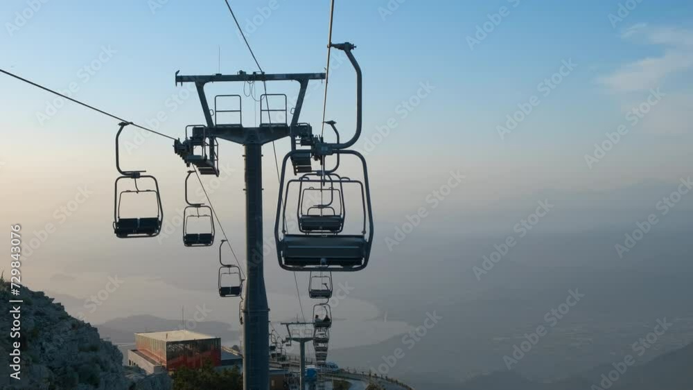 Silhouettes of cable cars over sea. Silhouettes of empty funiculars moving during morning time in summer. Silhouettes of cable cars over sea. Silhouettes of empty funiculars moving during morning time in summer.